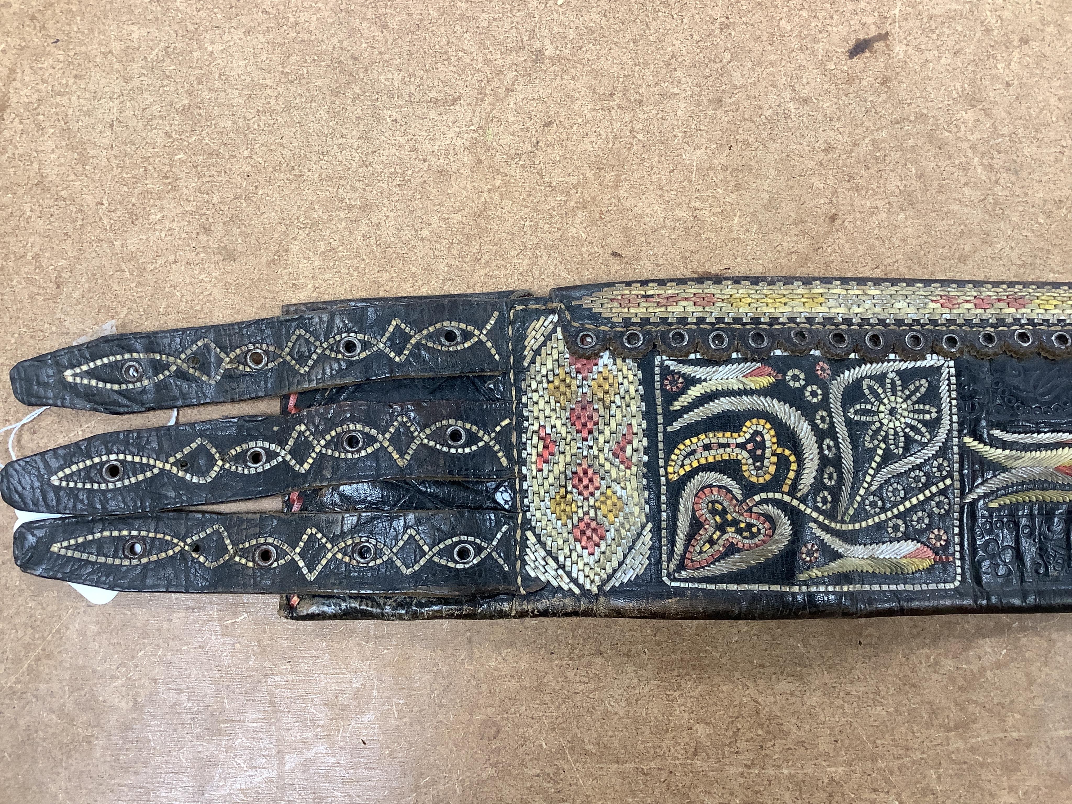 An Argentinian braided leather belt and whips, one with mother of pearl inlay